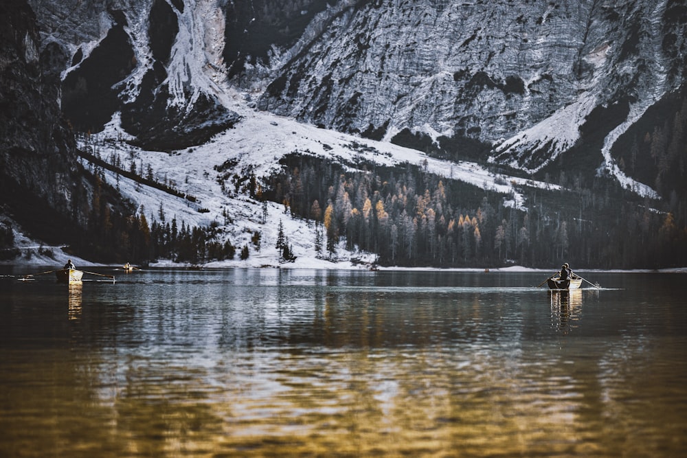 body of water in front of snow-covered mountains