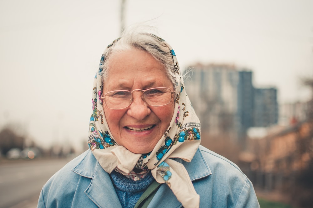 smiling woman in blue chambray collared top wearing eyeglasses