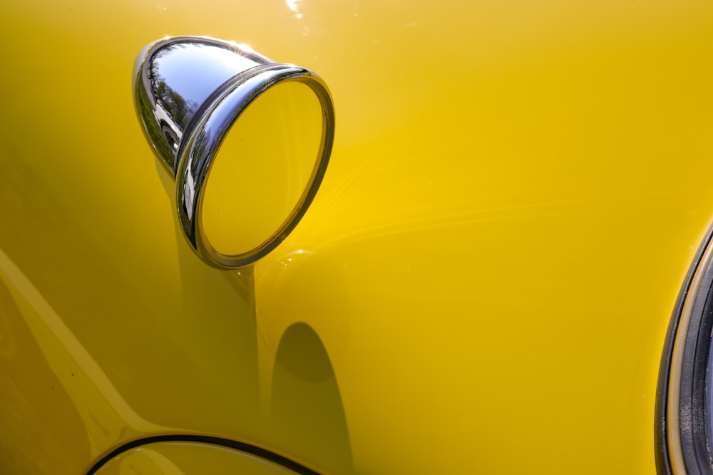 a close up of a yellow car with a chrome handle