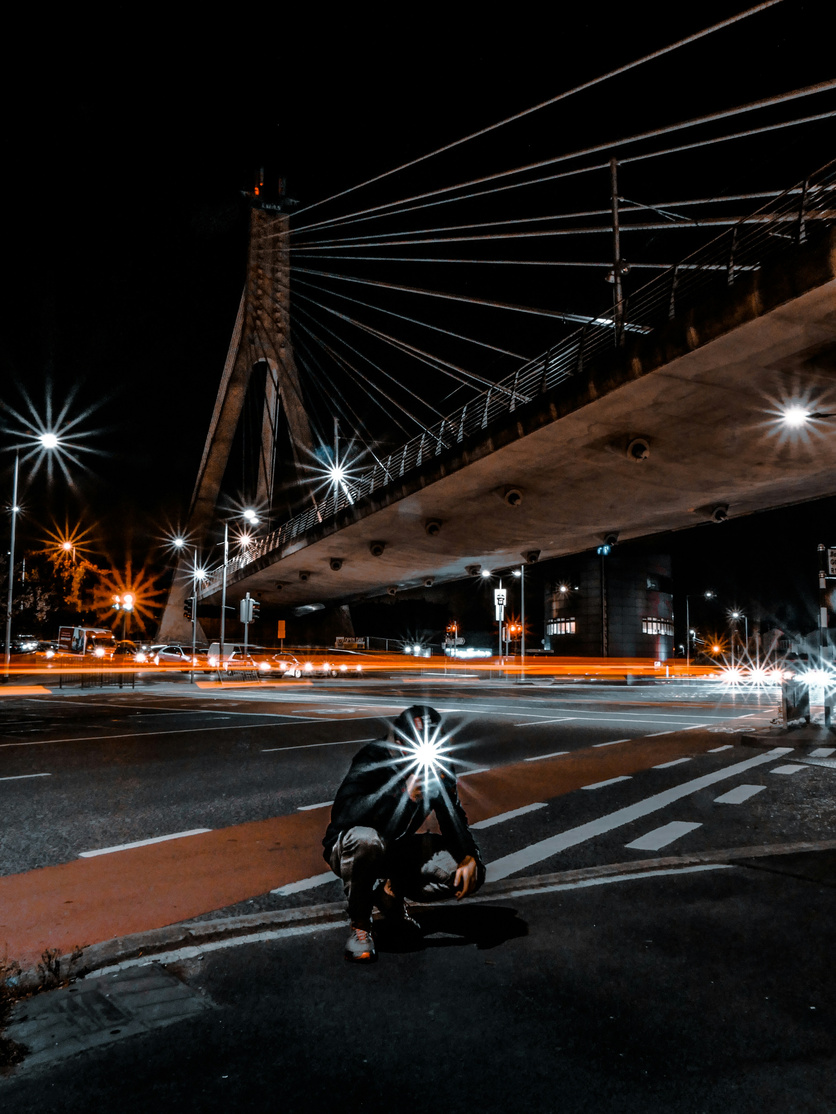 homme accroupi sur le chemin pendant la nuit