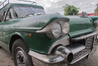 A close-up of a classic American car being carefully inspected before shipment.