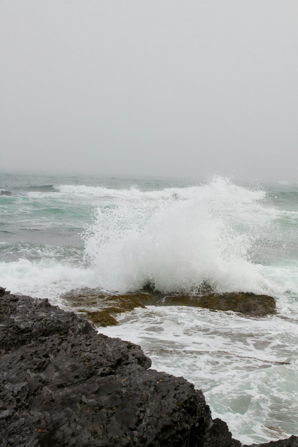 wave crashing on rock boulder