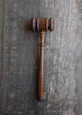 Close-up of legal documents and a gavel resting on a polished wooden desk.