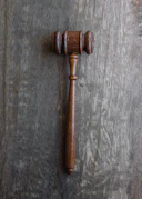 Close-up of legal documents and a gavel on a wooden desk.