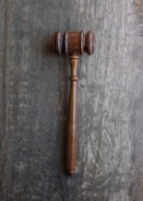 Close-up of legal documents and a gavel on a wooden table.