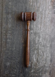 Close-up of legal documents and a gavel on a wooden desk.