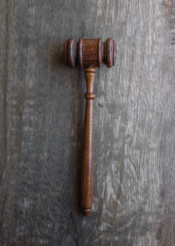Close-up of legal documents and a gavel on a graphite-colored desk.