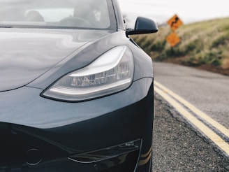 Close-up of a sleek car dashboard with a scenic curvy road visible through the windshield.