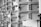A series of open mailboxes are aligned in a repeating pattern, with barcodes visible on the inside of some doors. The scene is captured in black and white, emphasizing the metal texture and geometrical design.