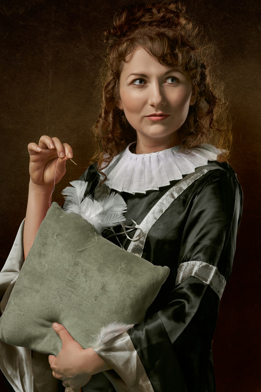 mujer mirando su lado izquierdo sosteniendo una almohada y a punto de coser