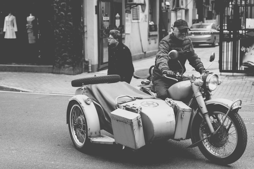 Foto en escala de grises de un hombre montando una motocicleta