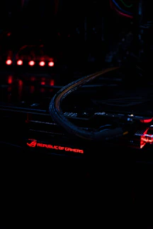 Dynamic close-up of a high-performance gaming motherboard illuminated by orange neon lighting.