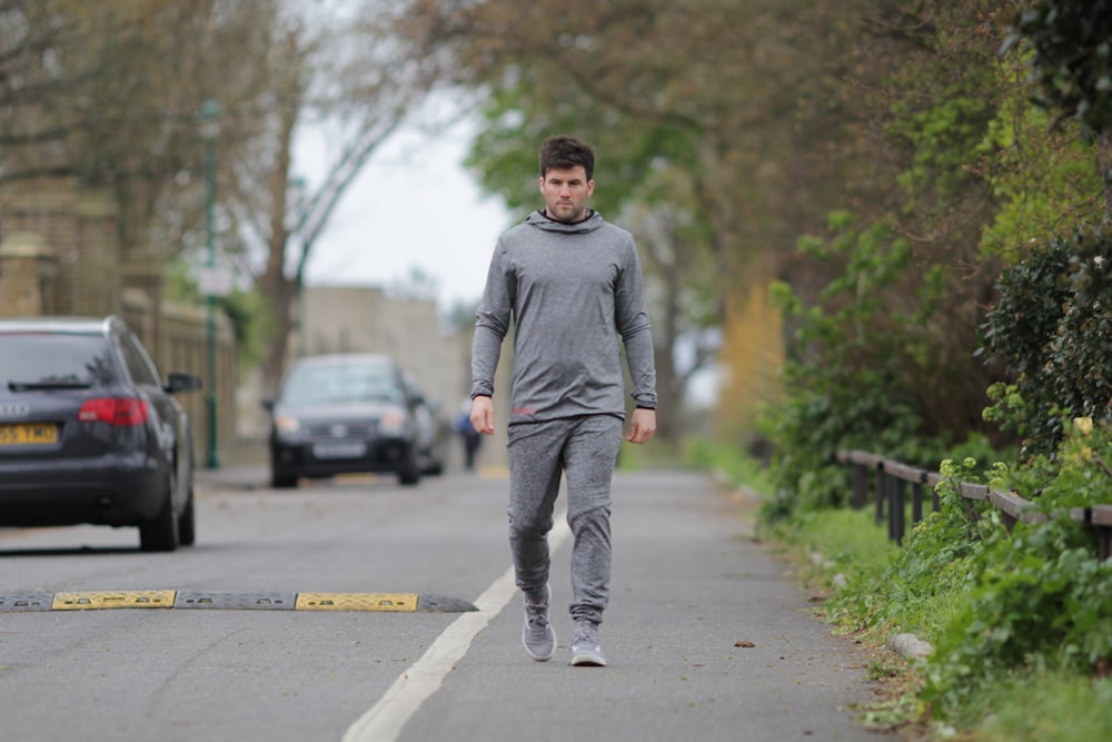 man walking on road near vehicles