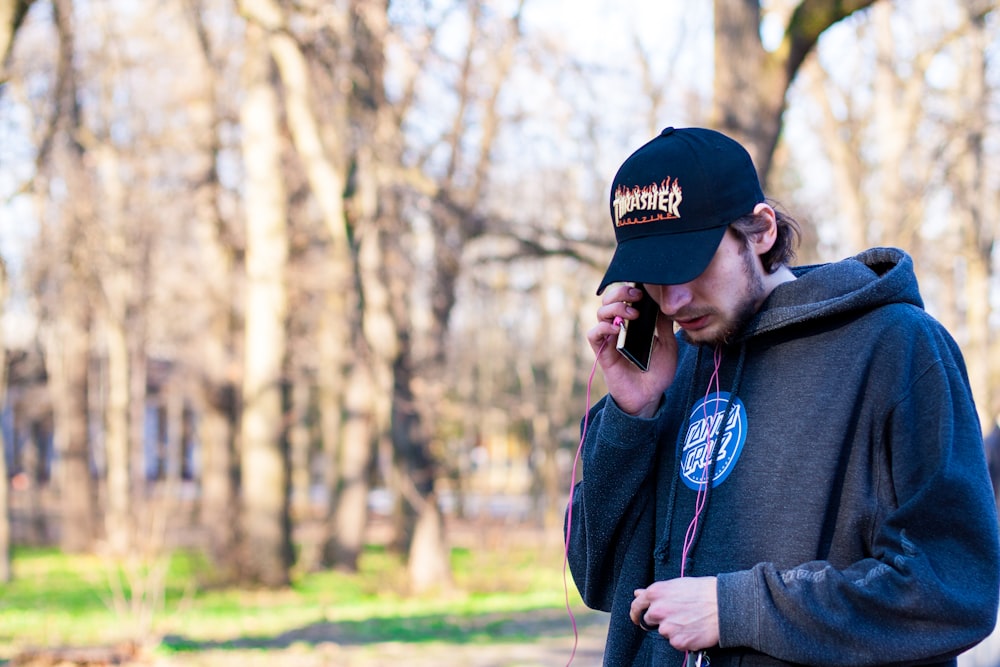 man wearing gray pullover using smartphone