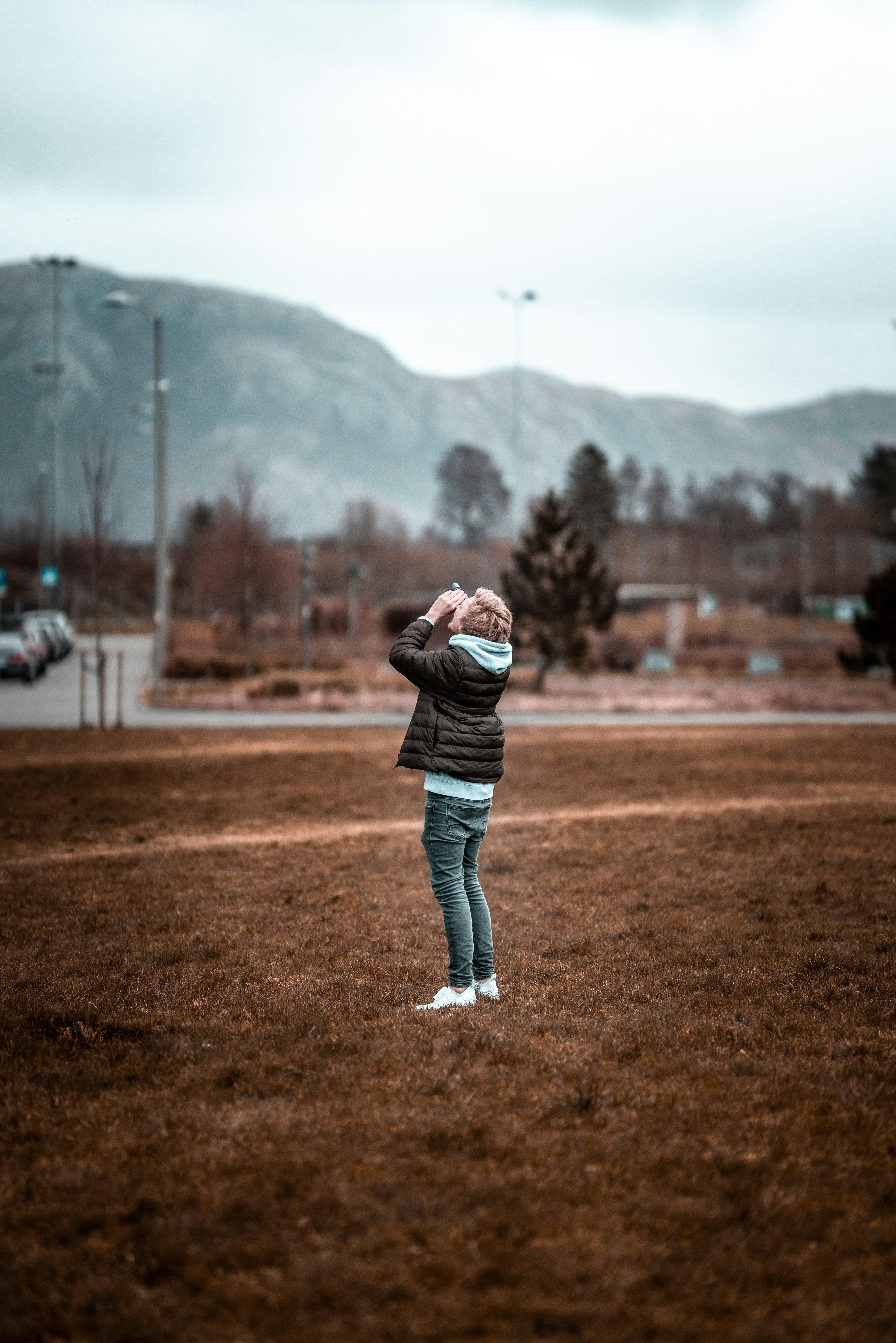 芝生の上に立つ黒いジャケットを着た人物の選択的焦点