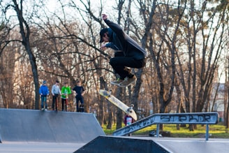 A group of skaters performing tricks at a skate park.