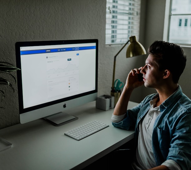 man in blue denim jacket facing turned on monitor