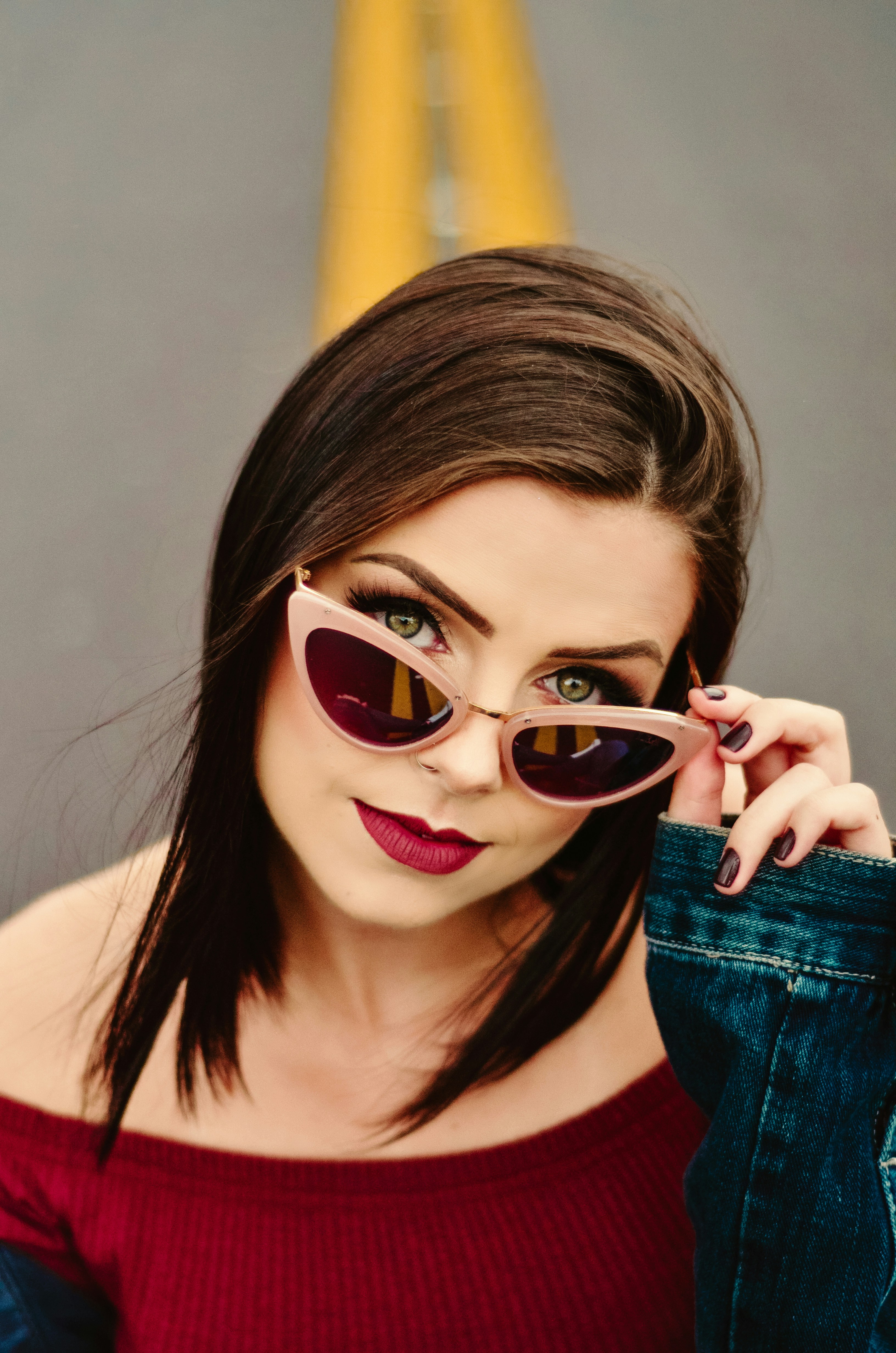 one unknown person holding pink framed black lens sunglasses
