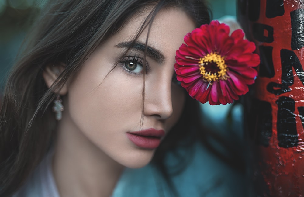 woman leaning on red-petaled flower