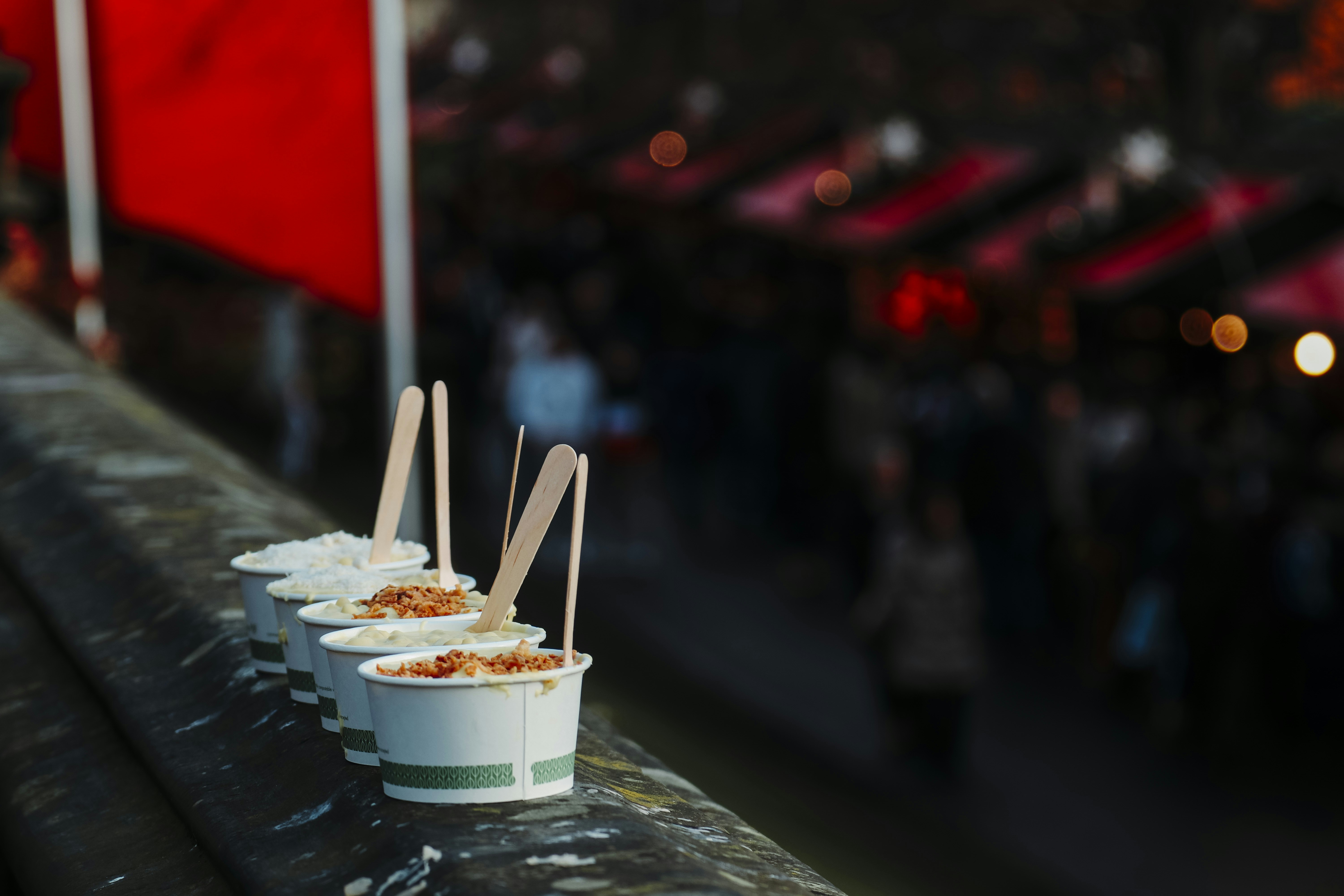Ice cream cups lined on a rail at night