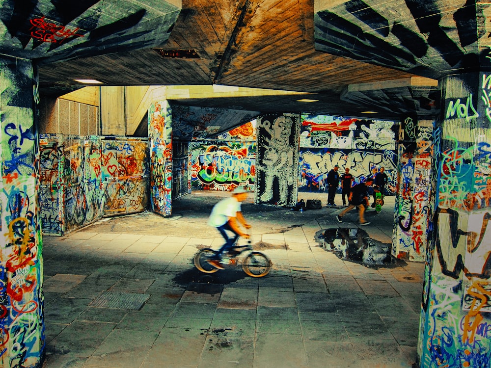 man wearing white shirt riding black BMX bike