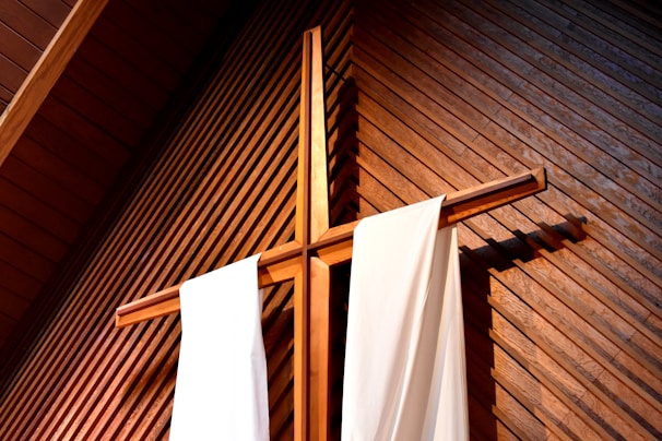 brown wooden cross against wall