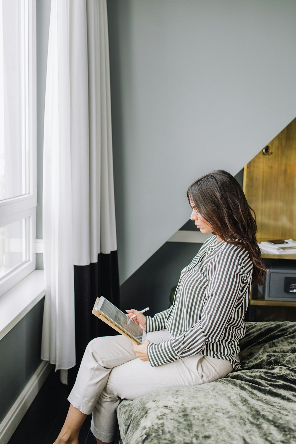 femme assise tout en roulant près d’une fenêtre en verre clair