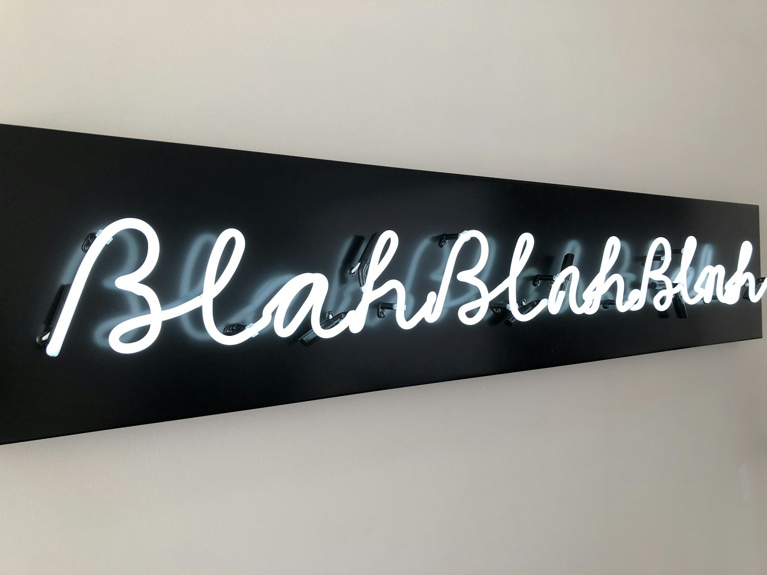 Black neon sign that reads "Blah blah blah" 