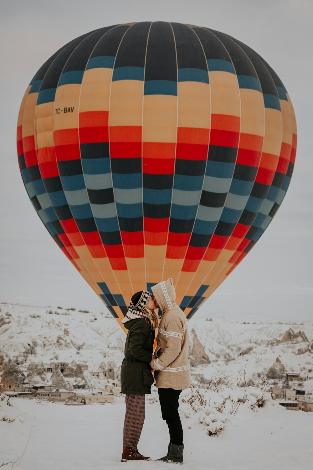 coupe kissing standing near hot air balloon