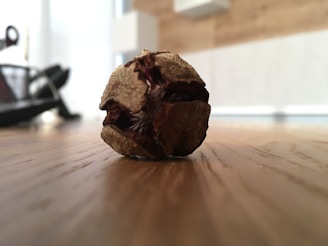 Sun-dried harmal seeds displayed on a wooden surface.