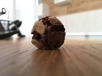 Sun-dried harmal seeds displayed on a wooden surface.