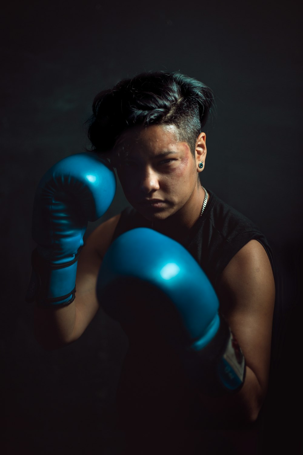 man wearing black tank top and pair of boxing gloves