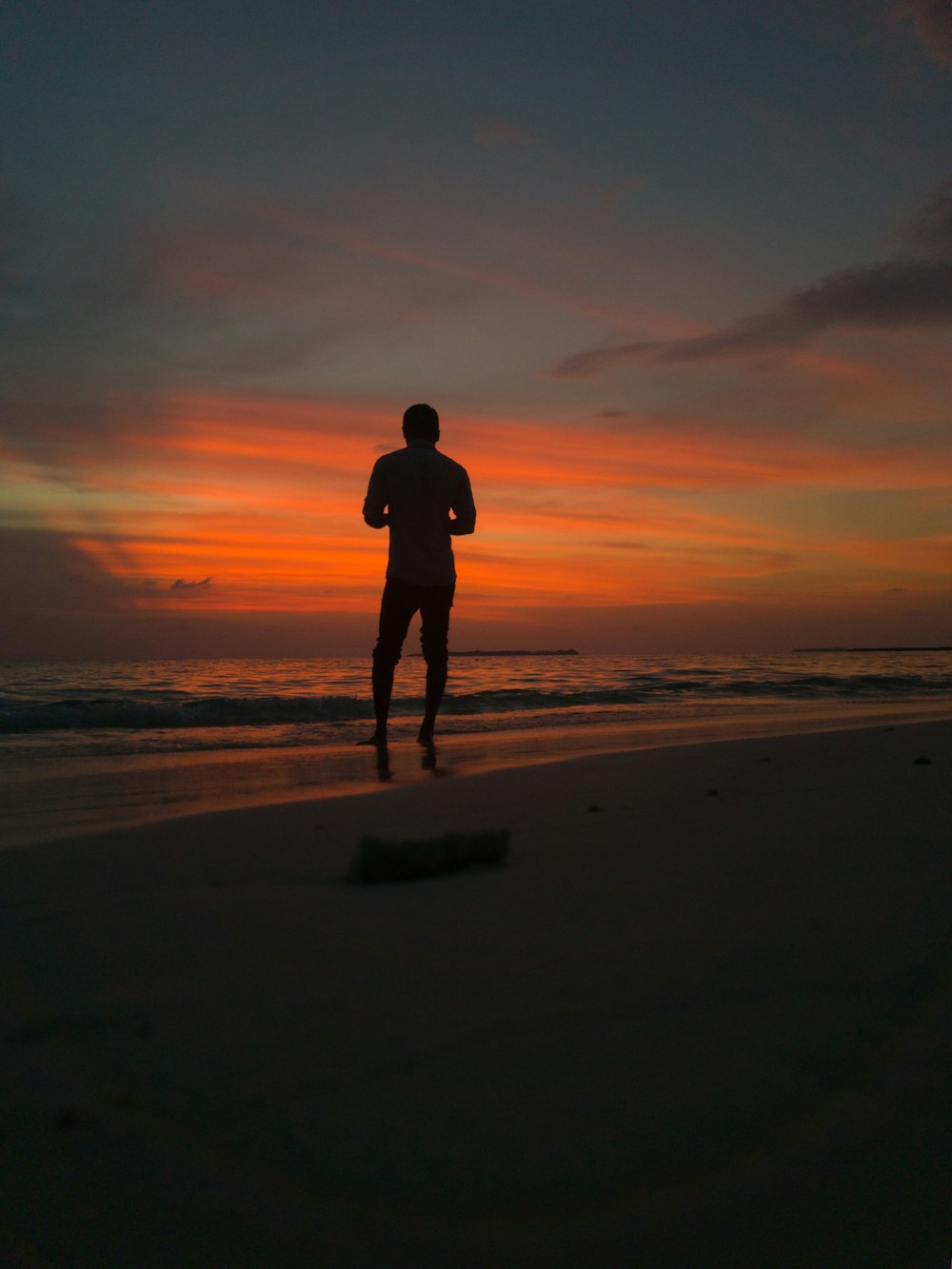 silhouette of man standing on shore