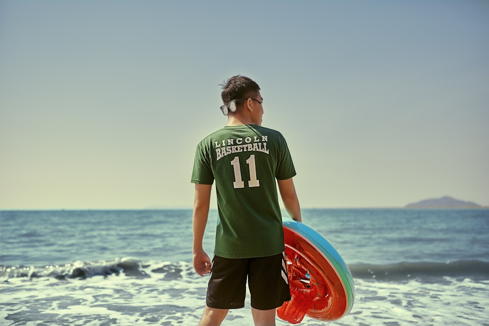 man holding floater in front of seashore