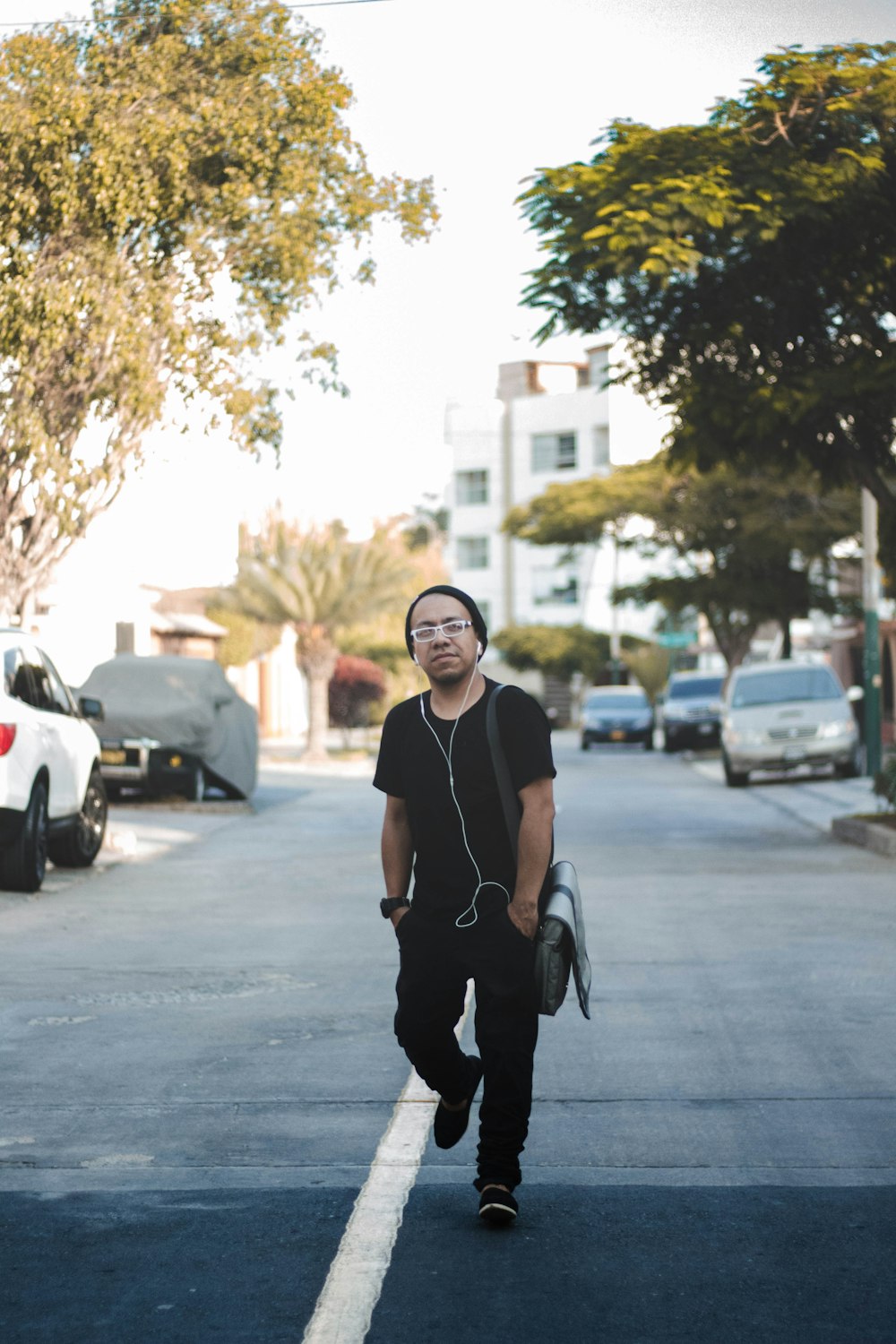 man standing on road near cars