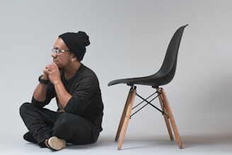 man sitting near black chair