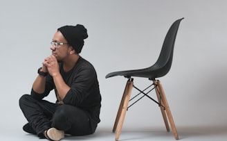 man sitting near black chair