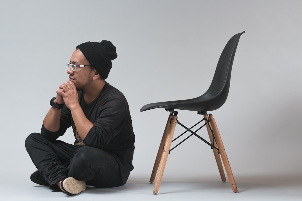 man sitting near black chair