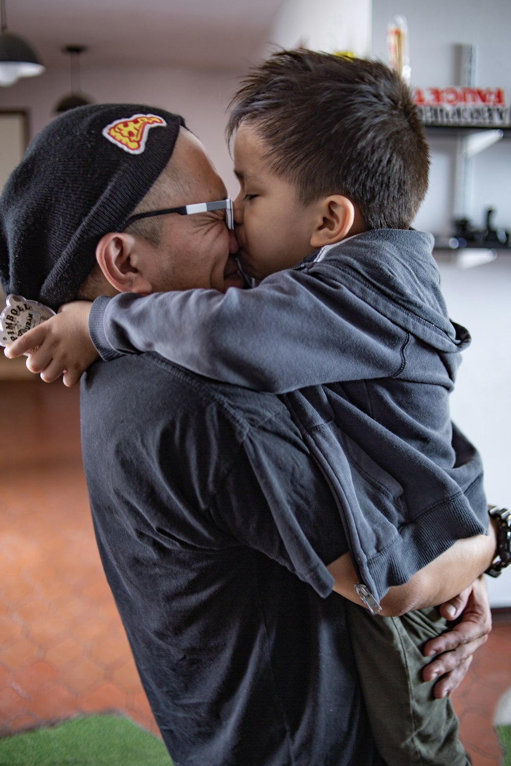 boy kissing the nose of man