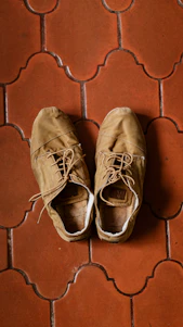 Close-up of a pair of sturdy, stylish safety shoes resting on a wooden floor with soft natural light.