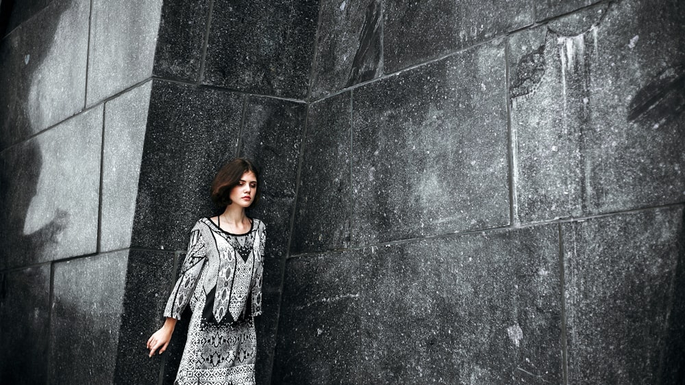 woman leaning on wall during daytime