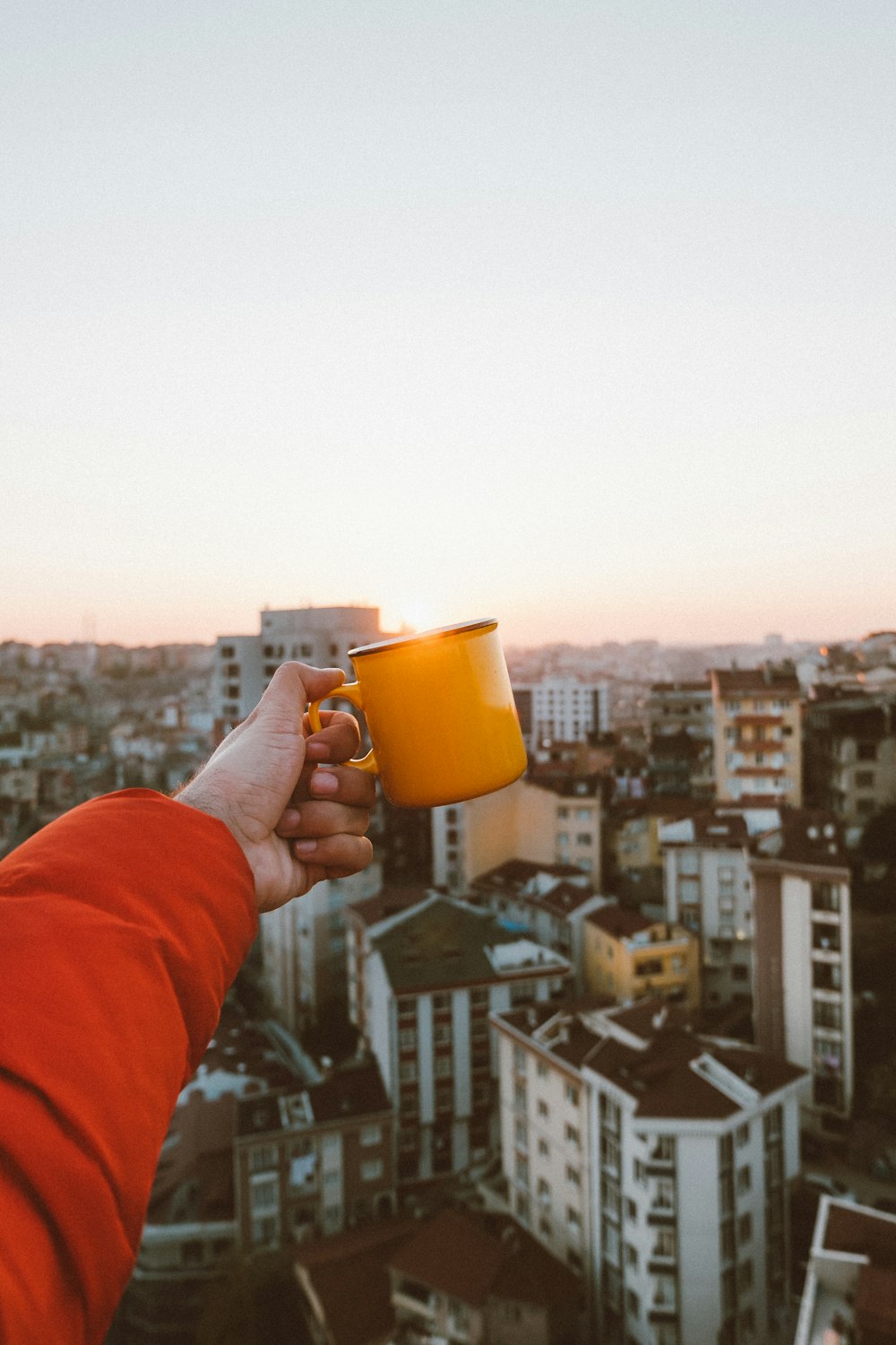 person holding yellow ceramic mug