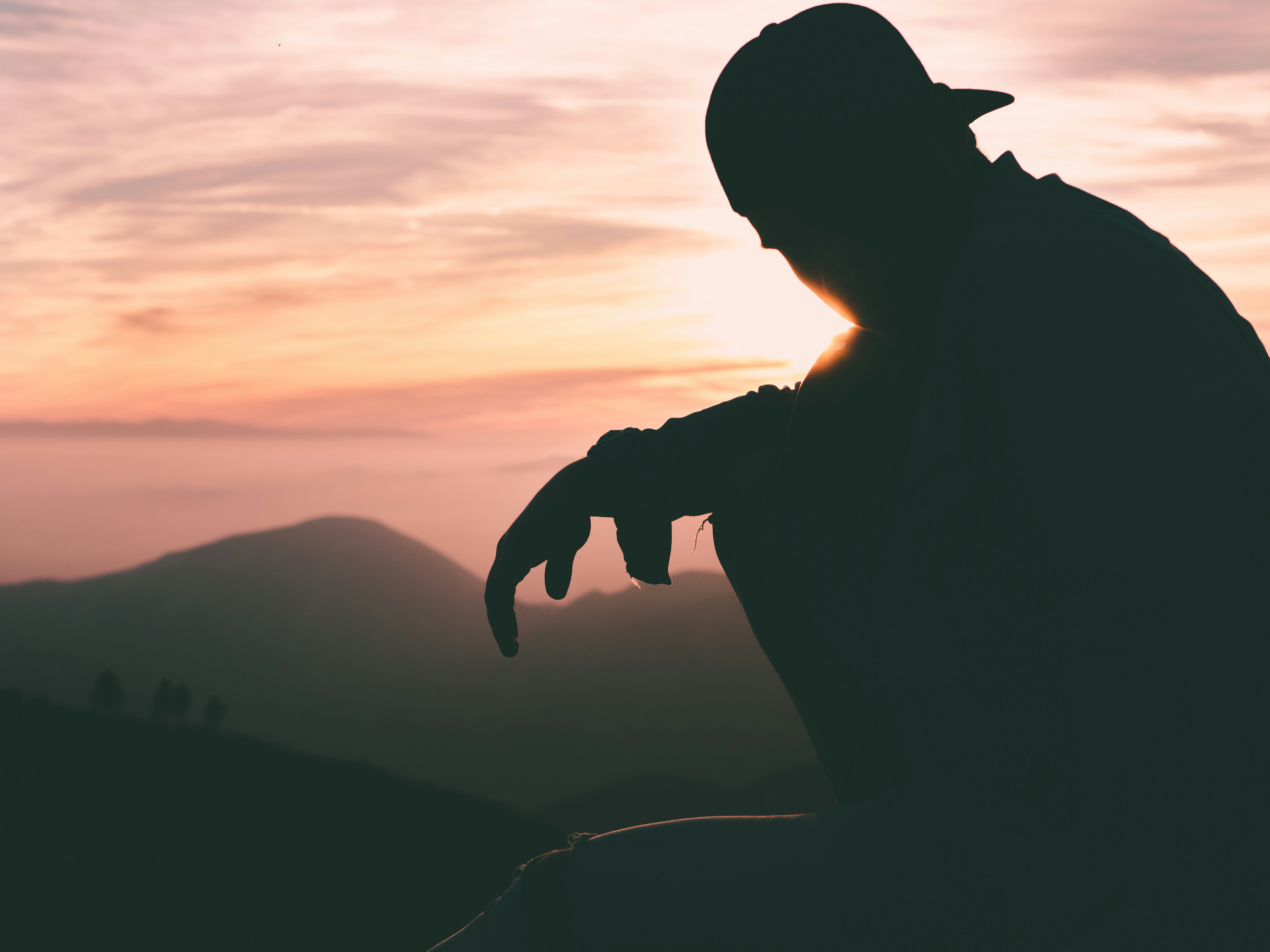 silhouette of person wearing cap