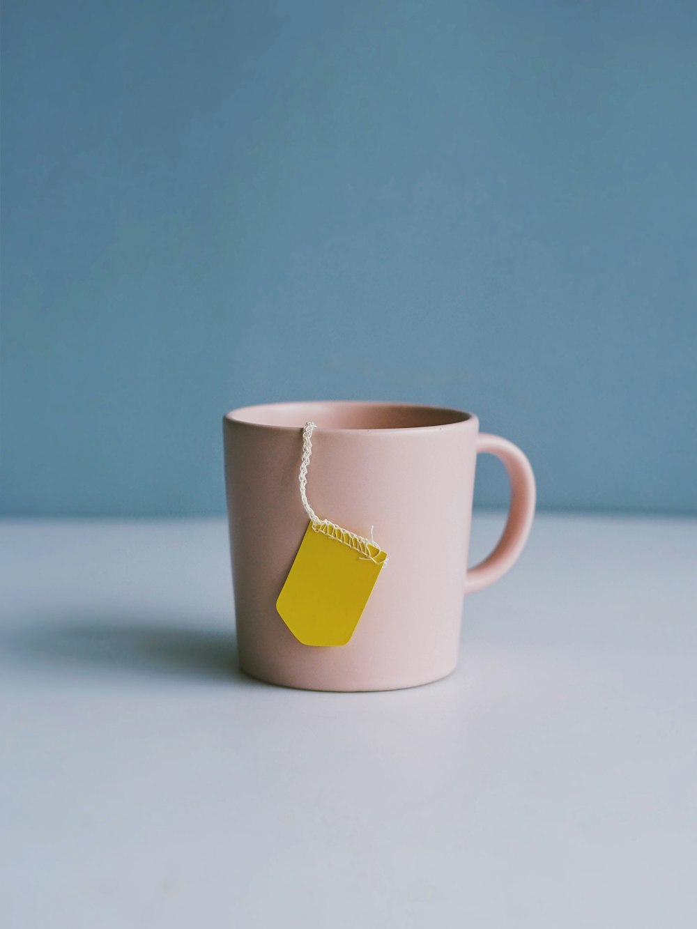 white ceramic mug on white surface