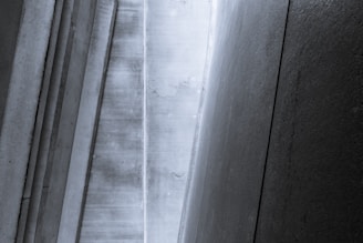 Vertical and angled concrete panels create a geometric pattern with a minimalist and industrial aesthetic.