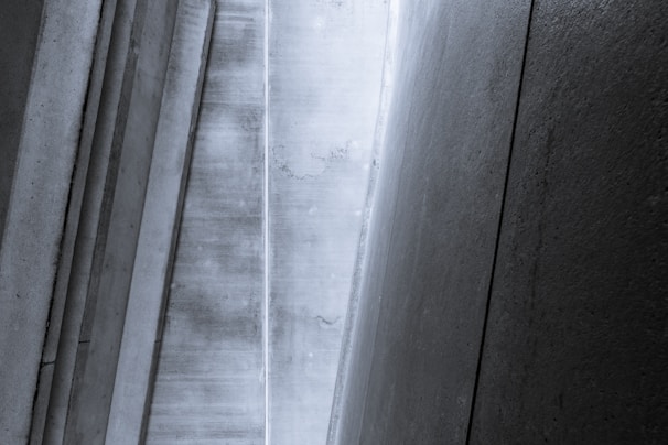 Vertical and angled concrete panels create a geometric pattern with a minimalist and industrial aesthetic.