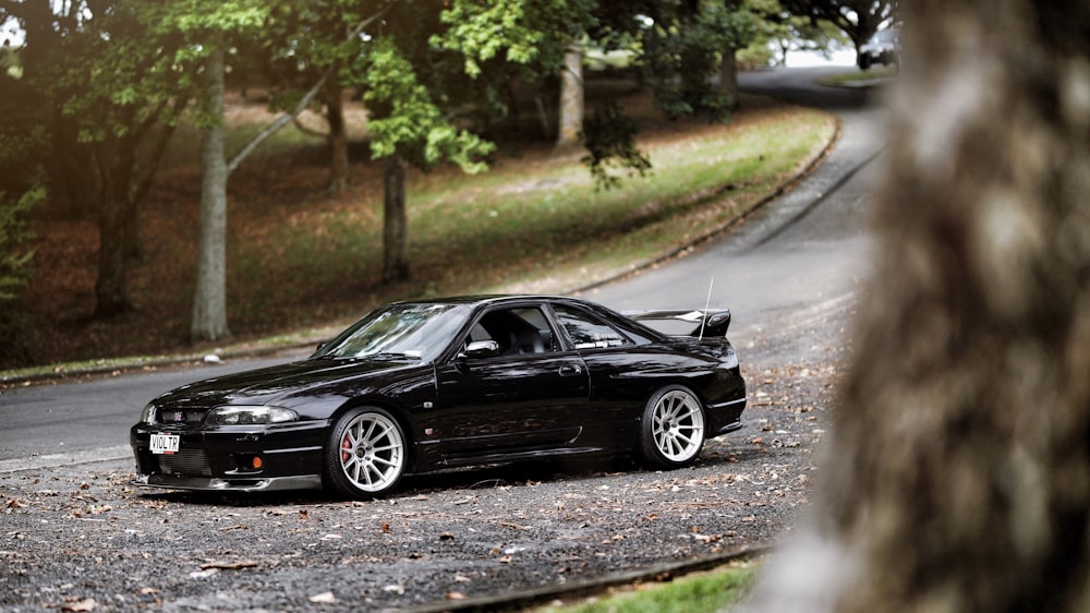 black coupe passing by asphalt road