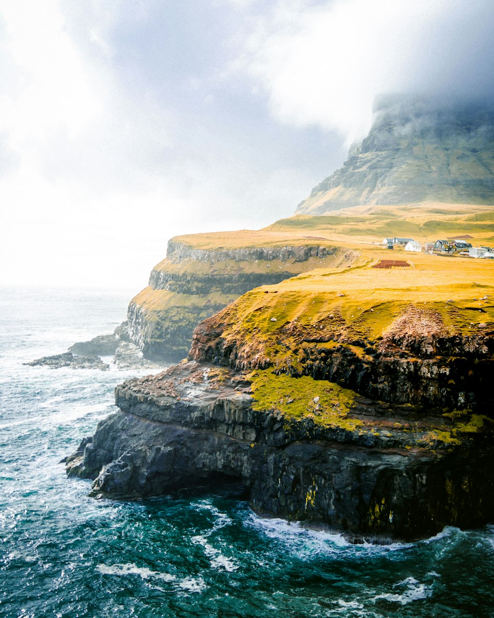 nature photography of sea cliff under cloudy sky during daytime