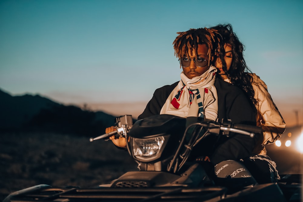 man and woman riding on ATV