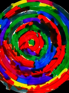 Close-up of a vibrant spiral tie-dye shirt blending bright pinks, blues, and yellows.